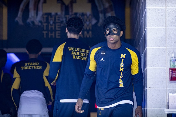 Jace Howard (25) and Michigan Team