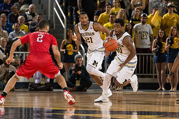 Zak Irvin (21) and Derrick Walton Jr. (10)