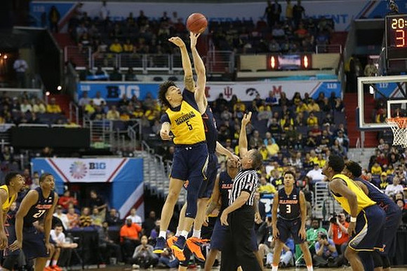 Zak Irvin (21), D.J. Wilson (5), and Derrick Walton Jr. (10)