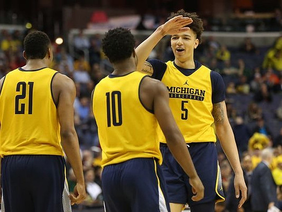 Zak Irvin (21), Derrick Walton Jr. (10), and D.J. Wilson (5)