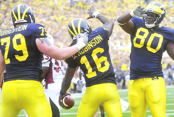 Perry Dorrestein (79), Denard Robinson (16), and Martell Webb (80)