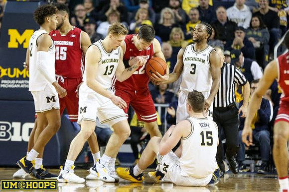 Jordan Poole (2), Ignas Brazdeikis (13), Zavier Simpson (3), and Jon Teske (15)