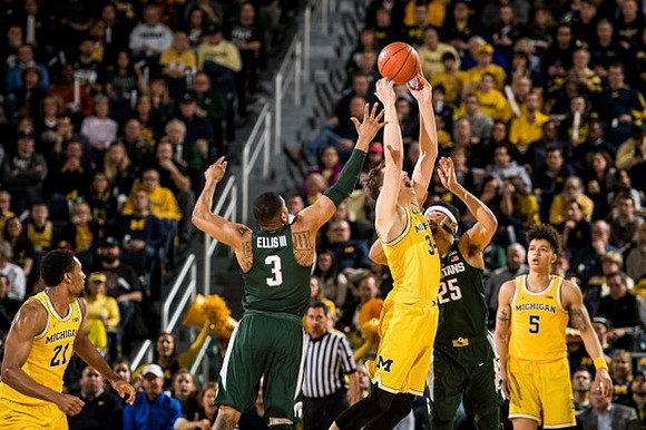 Zak Irvin (21), Mark Donnal (34), and D.J. Wilson (5)