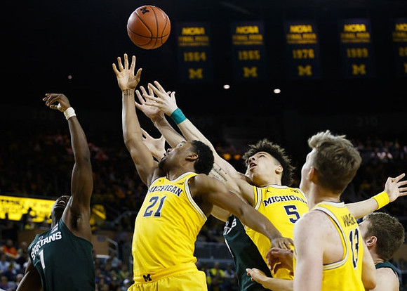 Zak Irvin (21), D.J. Wilson (5), and Moritz Wagner (13)