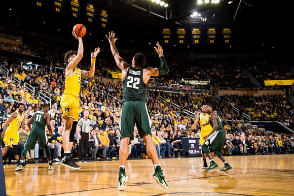 Derrick Walton Jr. (10), D.J. Wilson (5), and Xavier Simpson (3)