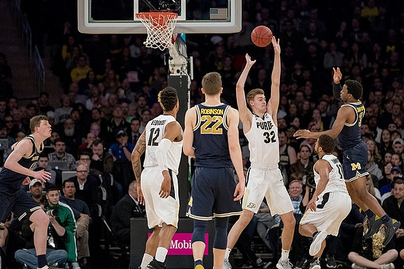 Jon Teske (15), Duncan Robinson (22), and Zavier Simpson (3)