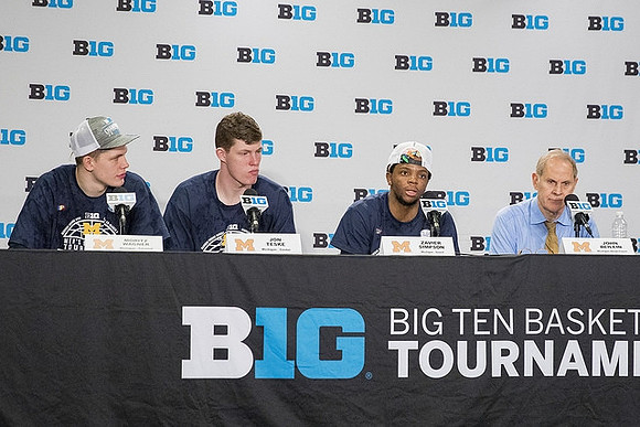 Moritz Wagner (13), Jon Teske (15), Zavier Simpson (3), and John Beilein