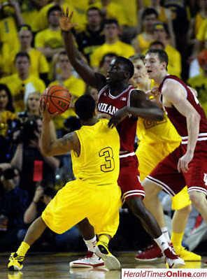 Trey Burke (3) and Blake McLimans (22)