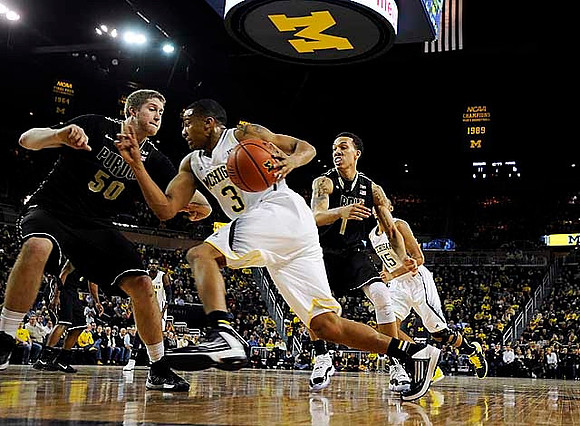 Trey Burke (3) and  Jon Horford (15)