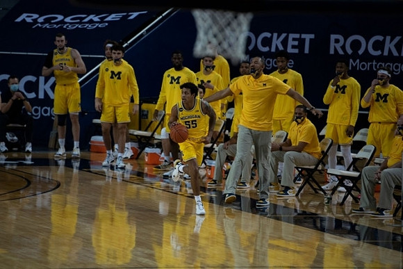 Eli Brooks (55), Juwan Howard, and Michigan Team
