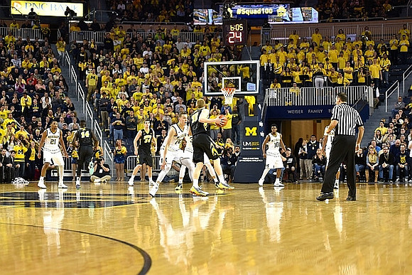 Zak Irvin (21), Duncan Robinson (22), and Derrick Walton Jr. (10)
