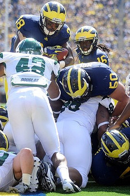 Fitzgerald Toussaint (28), David Molk (50), and Denard Robinson (16)