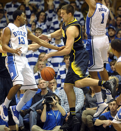 Mitch McGary (4), Caris LeVert (23), and Derrick Walton Jr. (10)