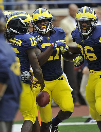 Denard Robinson (16), Junior Hemingway (21), and Kevin Koger (86)