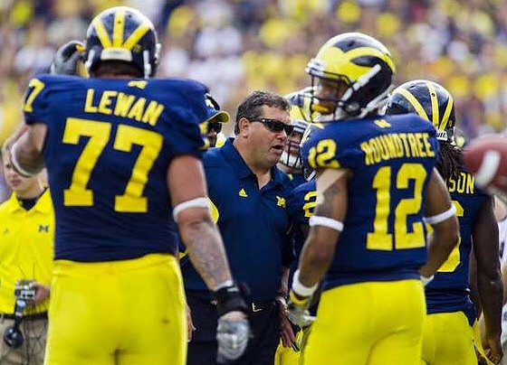 Taylor Lewan (77), Brady Hoke, Roy Roundtree (12), and Denard Robinson (16)