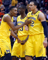 Zak Irvin (21), Caris LeVert (23), and Jordan Morgan (52)