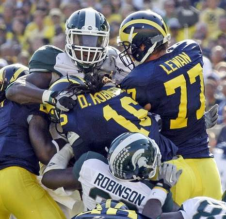 Vincent Smith (2), Denard Robinson (16), and Taylor Lewan (77)