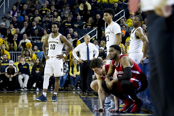 Derrick Walton Jr. (10), John Beilein, Ibi Watson (23), and Xavier Simpson (3)