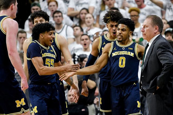Jon Teske (15), Brandon Johns Jr. (23), Eli Brooks (55), Jordan Poole (2), David DeJulius (0), and Michigan State Head Coach Tom Izzo