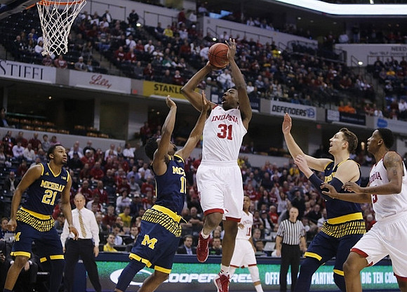 Zak Irvin (21), Derrick Walton Jr. (10), and Mark Donnal (34)