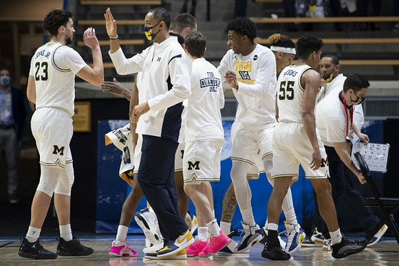 Brandon Johns Jr. (23), Juwan Howard, and Michigan Team
