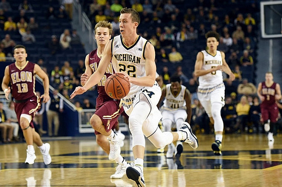 Duncan Robinson (22), Derrick Walton Jr. (10), and D.J. Wilson (5)