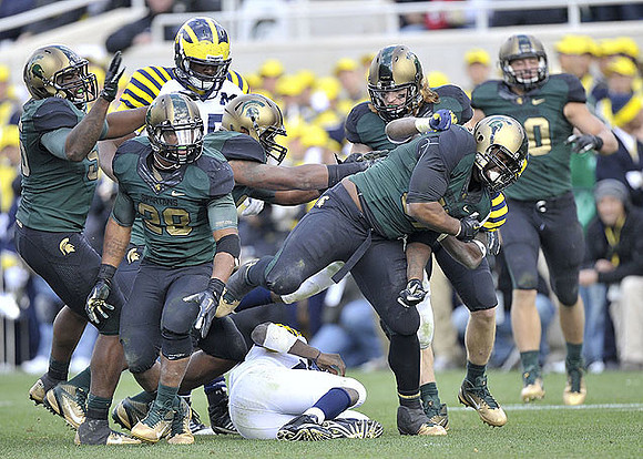 Patrick Omameh (65) and Denard Robinson (16)