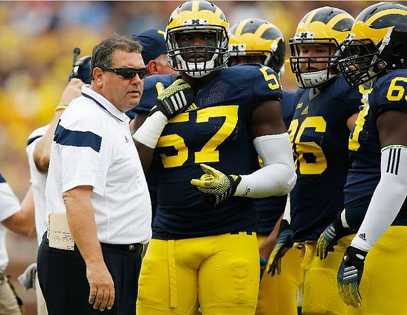 Brady Hoke, Frank Clark (57), Ryan Glasgow (96), and Willie Henry (69)