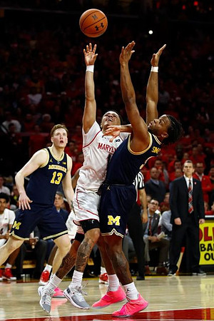 Ignas Brazdeikis (13), Zavier Simpson (3), and Maryland Head Coach Mark Turgeon