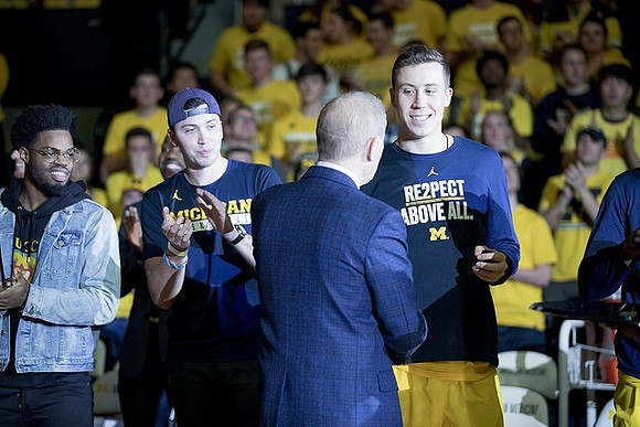 John Beilein, Duncan Robinson (22), and Derrick Walton Jr.