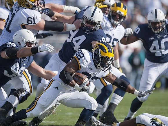Graham Glasgow (61), Karan Higdon (22), and Jake Butt (88)