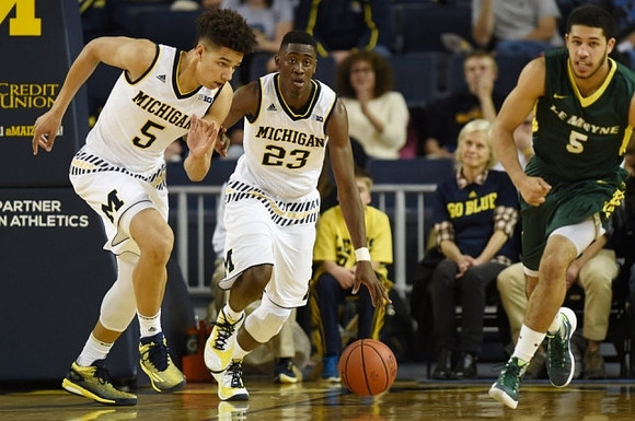D.J. Wilson (5) and Caris LeVert (23)
