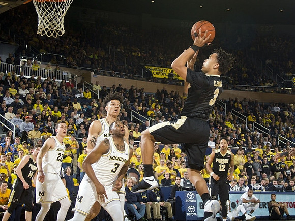 Duncan Robinson (22), D.J. Wilson (5), and Xavier Simpson (3)