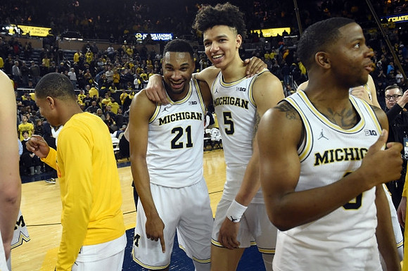 Zak Irvin (21), D.J. Wilson (5), and Xavier Simpson (3)