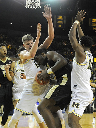 D.J. Wilson (5), Moritz Wagner (13), and Derrick Walton Jr. (10)