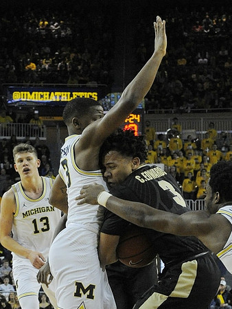 Moritz Wagner (13), Xavier Simpson (3), and Derrick Walton Jr. (10)