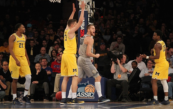 Zak Irvin (21), Moritz Wagner (13), and Derrick Walton Jr. (10)