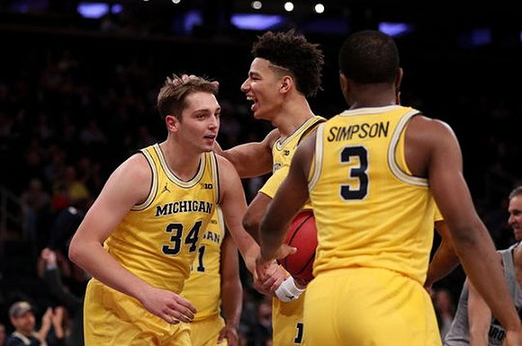 Mark Donnal (34), D.J. Wilson (5), and Xavier Simpson (3)