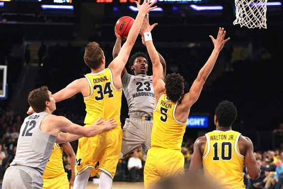 Mark Donnal (34), D.J. Wilson (5), and Derrick Walton Jr. (10)
