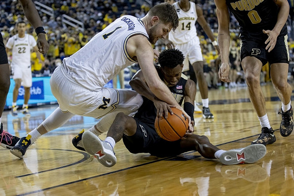 Hunter Dickinson (1), Caleb Houstan (22), and Moussa Diabate (14)