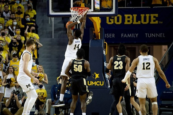 Hunter Dickinson (1), Moussa Diabate (14), and DeVante' Jones (12)