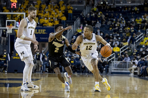 Hunter Dickinson (1) and DeVante' Jones (12)