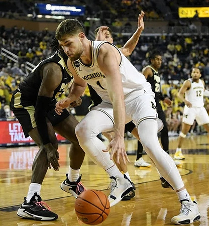 Hunter Dickinson (1) and DeVante' Jones (12)