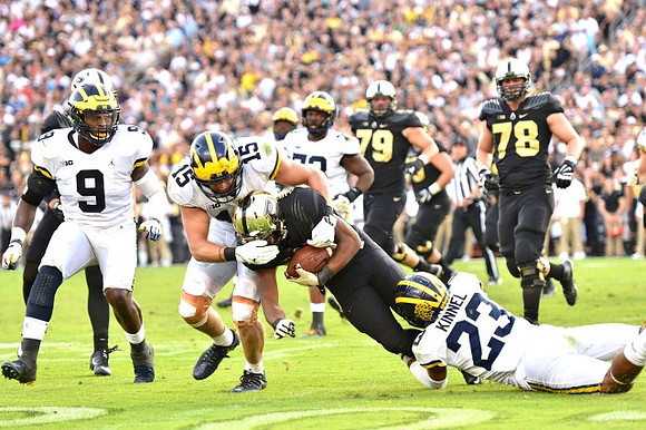 Mike McCray (9), Chase Winovich (15), and Tyree Kinnel (23)