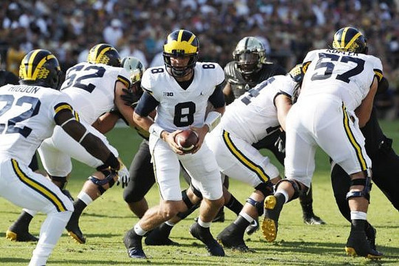 Karan Higdon (22), Mason Cole (52), John O'Korn (8), Ben Bredeson (74), and Patrick Kugler (57)