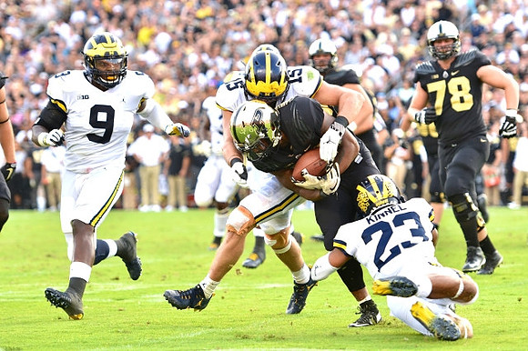 Mike McCray (9), Chase Winovich (15), and Tyree Kinnel (23)