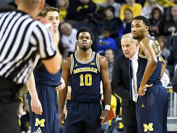 Mark Donnal (34), Derrick Walton Jr. (10), John Beilein, and Zak Irvin (21)