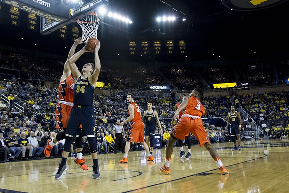 Mark Donnal (34), D.J. Wilson (5), and Derrick Walton Jr. (10)