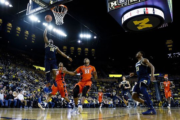 Derrick Walton Jr. (10), D.J. Wilson (5), and Zak Irvin (21)