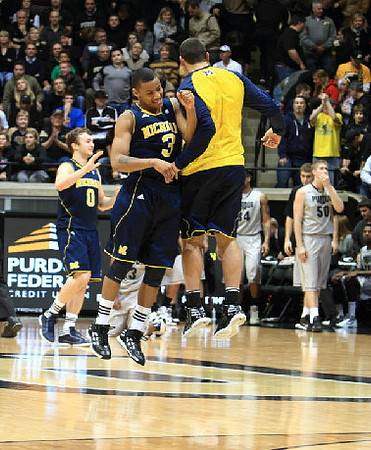 Zack Novak (0), Trey Burke (3), and Josh Bartelstein (20)